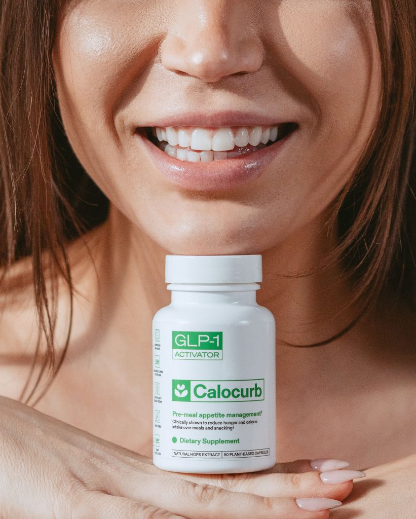 Smiling woman holding a bottle of Calocurb GLP-1 Activator dietary supplement for pre-meal appetite management.